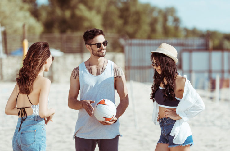 Die besten Sonnenbrillen für den Strand (einschließlich Wassersport und Beachvolleyball) Freunde spielen Volleyball am Strand.