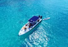 Bootstour ab St. Martin: Privater Charter nach Anguilla oder St. Barts Gäste entspannen an Bord eines privaten Motorboots im klaren türkisfarbenen Wasser