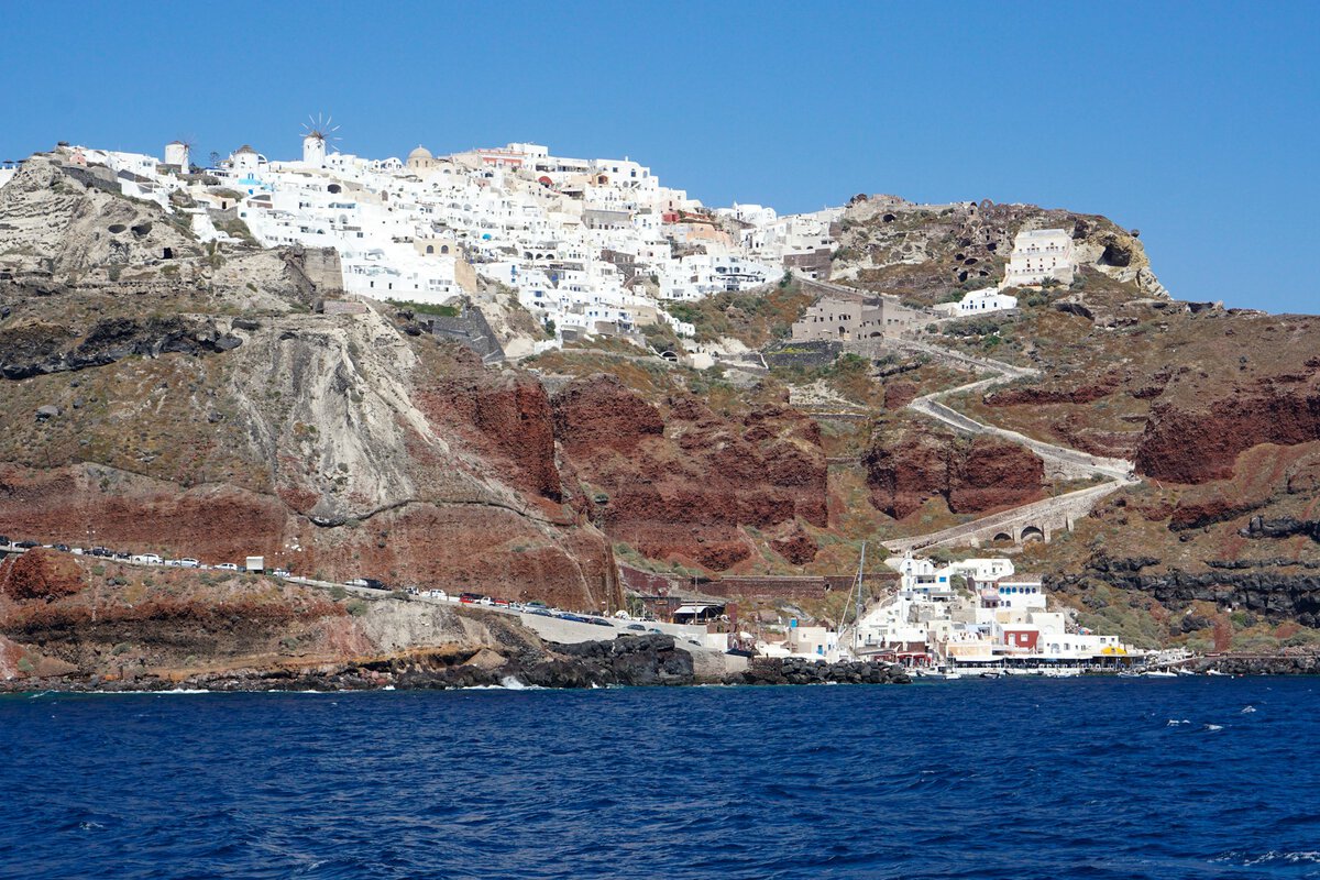 Malerisches Dorf auf Santorin mit weißen Gebäuden auf Klippen mit Blick aufs Meer.